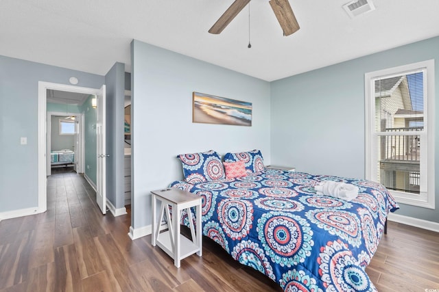 bedroom featuring ceiling fan, attic access, baseboards, wood finished floors, and visible vents