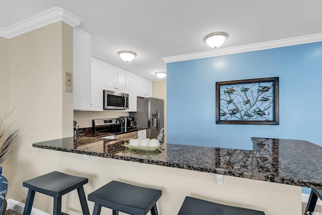 kitchen featuring stainless steel appliances, white cabinets, kitchen peninsula, and crown molding