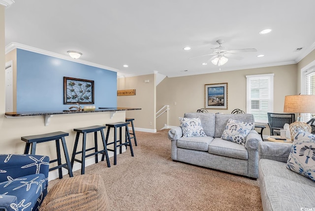 carpeted living room featuring ornamental molding and ceiling fan