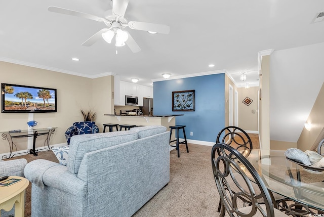 living room with ceiling fan, light colored carpet, and crown molding