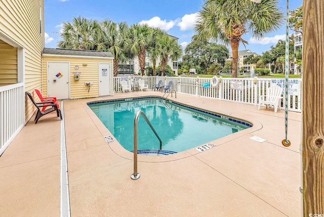 view of swimming pool with an outbuilding and a patio area