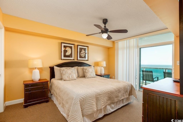 bedroom with a textured ceiling, access to exterior, and carpet flooring