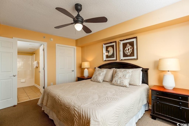 bedroom featuring tile patterned floors, a textured ceiling, ensuite bathroom, and a ceiling fan