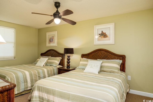 bedroom with ceiling fan, a textured ceiling, baseboards, and carpet