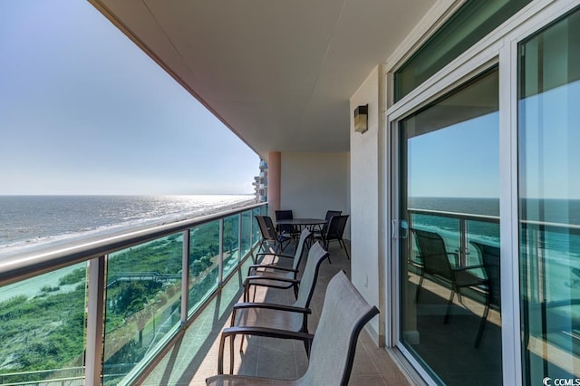 balcony featuring a water view and a view of the beach