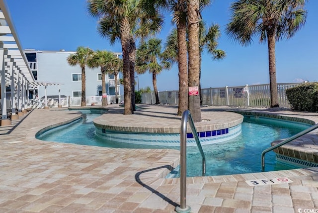 community pool featuring a patio area and fence