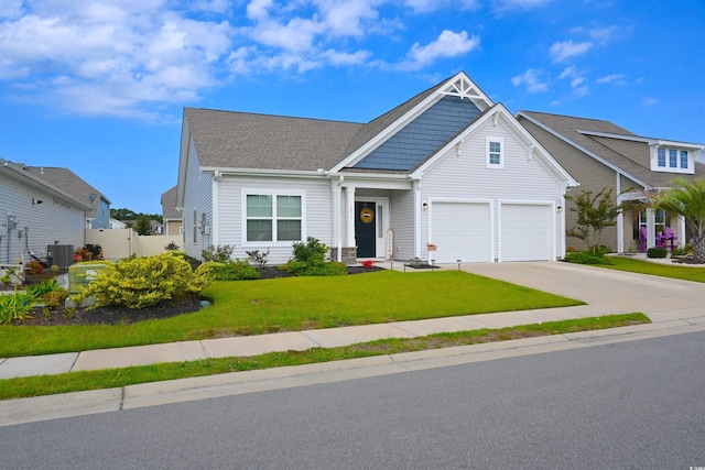 view of front of home featuring a front yard, central AC unit, and a garage