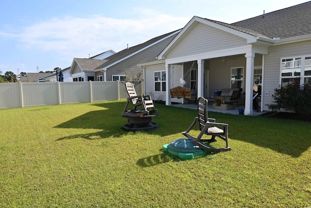 back of property featuring a patio, ceiling fan, an outdoor fire pit, and a lawn