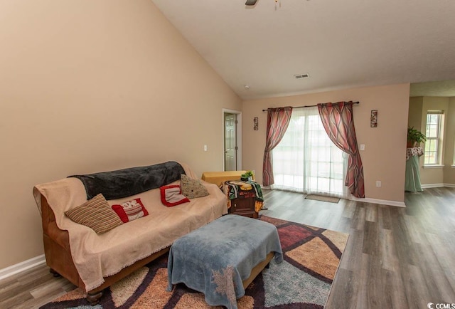 living room with high vaulted ceiling, a wealth of natural light, and wood-type flooring