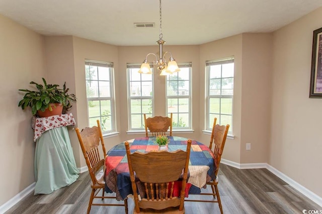 dining room with a notable chandelier, plenty of natural light, and dark wood-type flooring