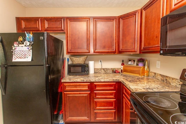 kitchen featuring light stone counters, a textured ceiling, and black appliances