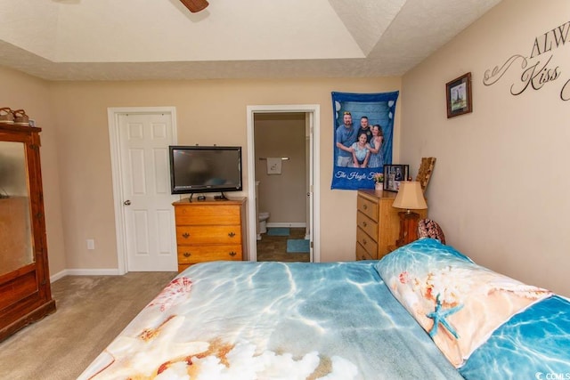 bedroom with ceiling fan, light colored carpet, and ensuite bathroom