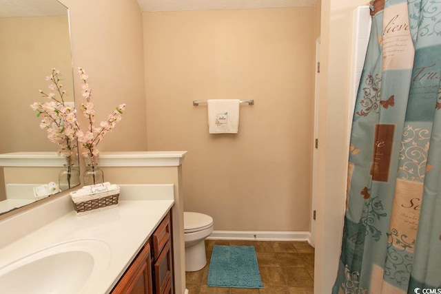 bathroom featuring vanity, toilet, a textured ceiling, and tile patterned floors