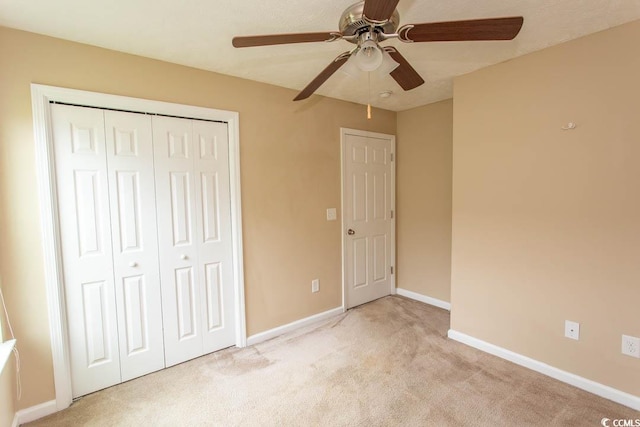 unfurnished bedroom featuring light carpet, a closet, and ceiling fan