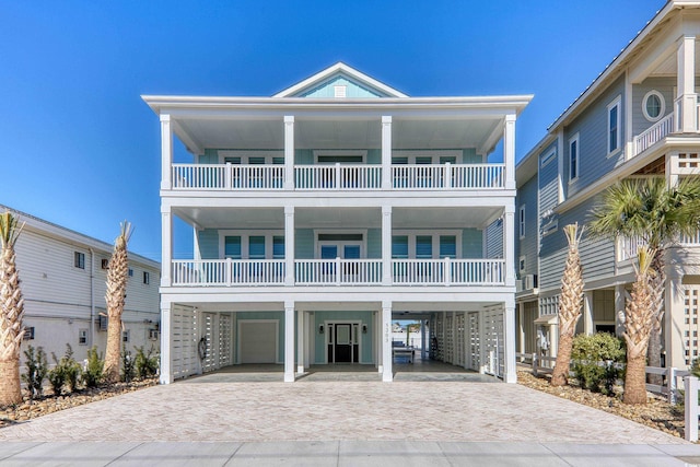 beach home featuring decorative driveway, a carport, and a garage