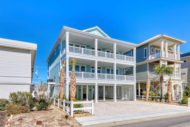 coastal inspired home featuring a balcony and a carport