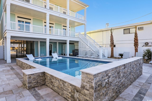 view of swimming pool featuring a patio area, a fenced in pool, stairs, and fence