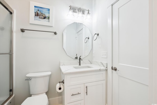 full bath featuring vanity, toilet, and a shower with door