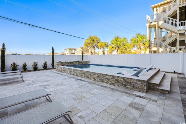 view of patio / terrace featuring stairway, a fenced backyard, and a fenced in pool