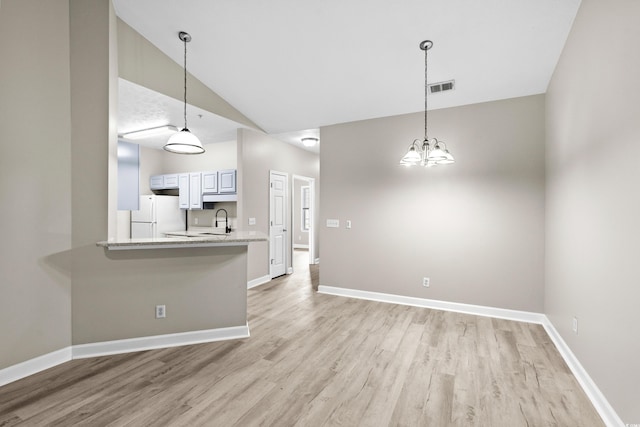 kitchen featuring white cabinets, kitchen peninsula, white refrigerator, light hardwood / wood-style flooring, and decorative light fixtures