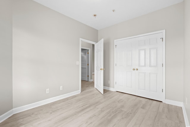 unfurnished bedroom featuring a closet and light hardwood / wood-style floors