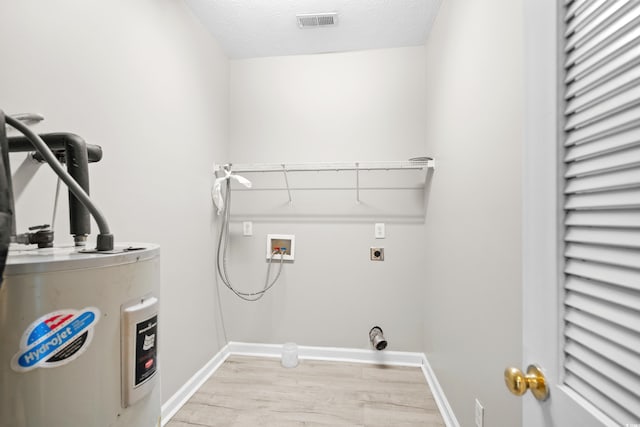 laundry area with washer hookup, light hardwood / wood-style floors, electric water heater, electric dryer hookup, and a textured ceiling