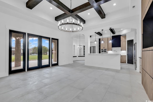 unfurnished living room featuring coffered ceiling, french doors, a chandelier, beamed ceiling, and arched walkways