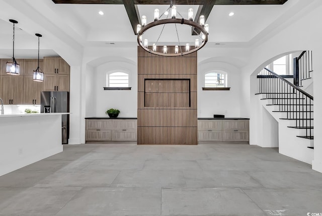 entryway featuring a towering ceiling, beamed ceiling, and plenty of natural light