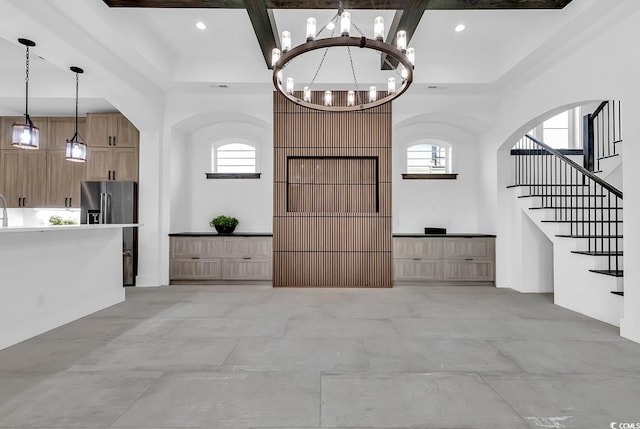 interior space featuring an inviting chandelier, coffered ceiling, and a healthy amount of sunlight