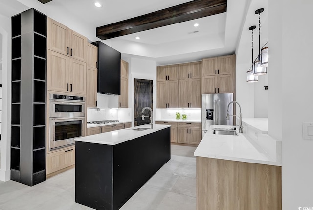 kitchen with pendant lighting, a center island with sink, sink, and stainless steel appliances