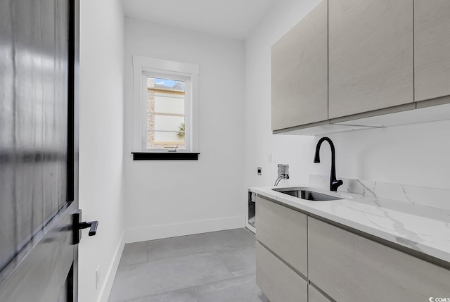 clothes washing area with cabinets, washer hookup, sink, electric dryer hookup, and light tile patterned floors