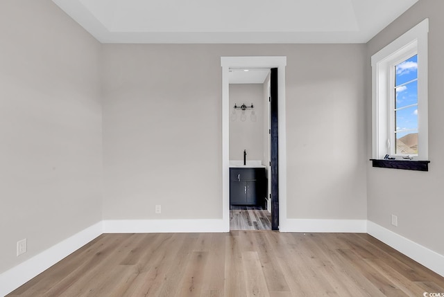 unfurnished room featuring light hardwood / wood-style flooring and sink