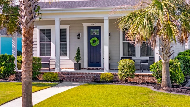 property entrance featuring covered porch and a lawn