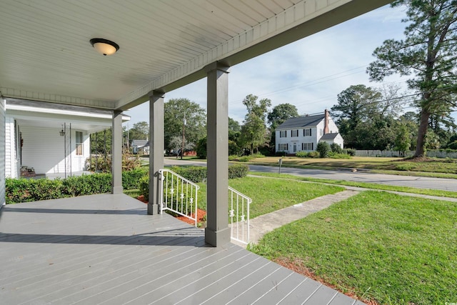 deck with a yard and covered porch