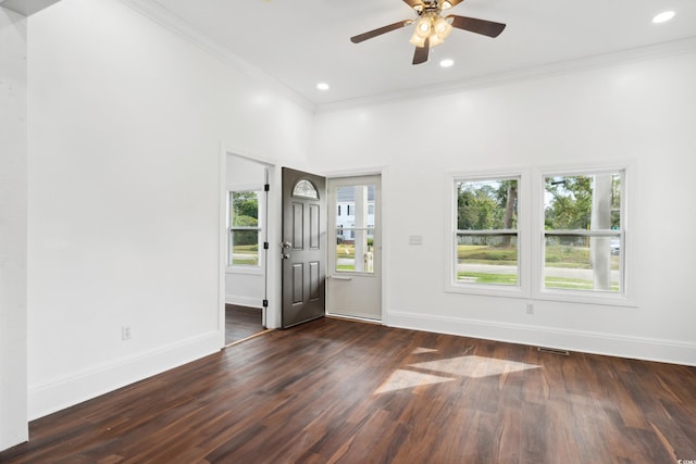 unfurnished room featuring crown molding, dark hardwood / wood-style flooring, ceiling fan, and plenty of natural light