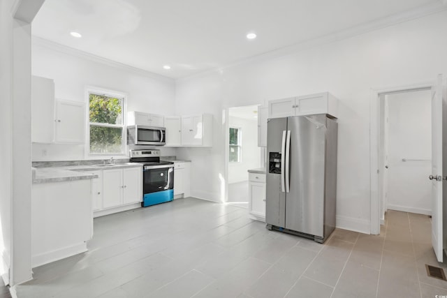 kitchen featuring ornamental molding, stainless steel appliances, white cabinets, and sink