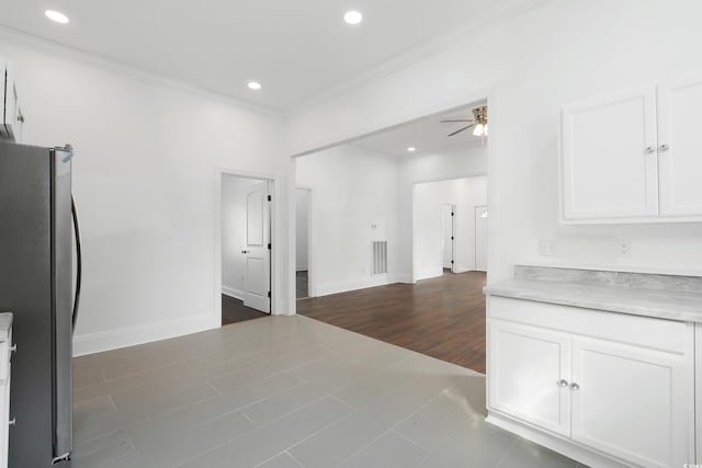 interior space featuring ceiling fan, ornamental molding, white cabinetry, stainless steel refrigerator, and dark hardwood / wood-style floors