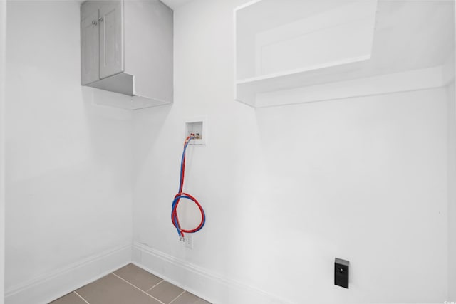 laundry room featuring hookup for a washing machine and dark tile patterned floors