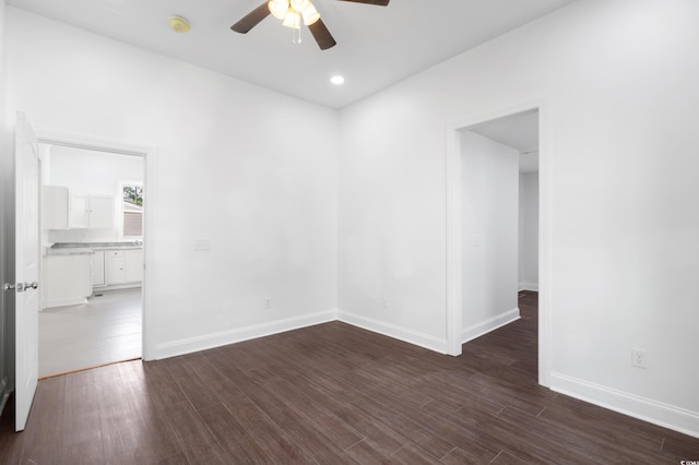 empty room with ceiling fan and dark wood-type flooring