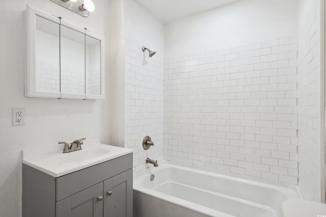 bathroom featuring tiled shower / bath and vanity