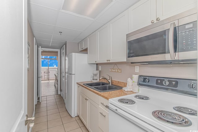 6900 N Ocean Blvd Unit 1040, Myrtle Beach, SC 29572 - kitchen featuring white appliances, a sink, light tile patterned floors, light countertops, and white cabinets