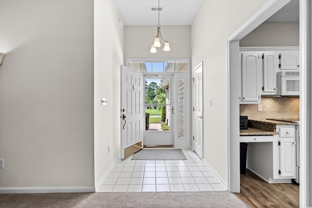 entryway featuring light tile patterned floors and a notable chandelier