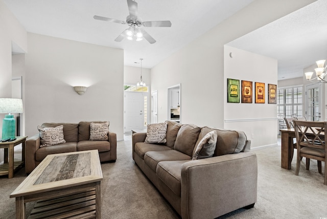 living room featuring carpet floors and ceiling fan with notable chandelier