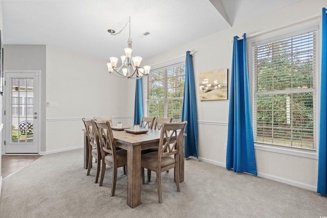 dining room with light colored carpet, an inviting chandelier, and a healthy amount of sunlight