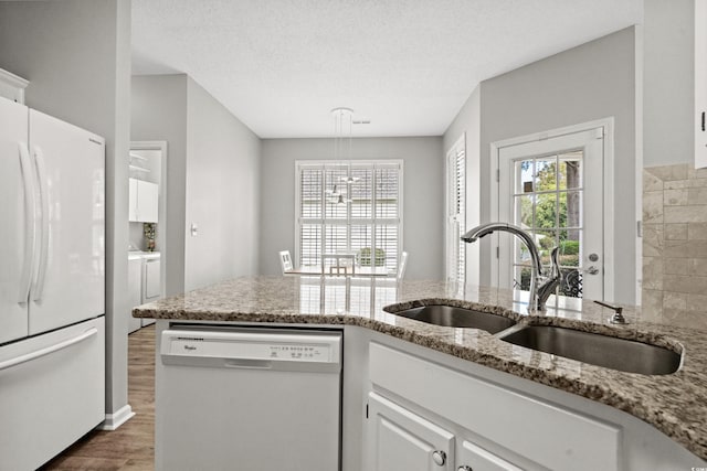 kitchen featuring white cabinetry, white appliances, light stone countertops, dark hardwood / wood-style floors, and sink