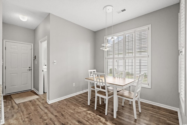 dining room with wood-type flooring, a textured ceiling, and an inviting chandelier