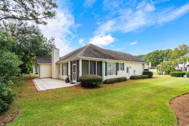 rear view of house with a lawn, a sunroom, and a patio area