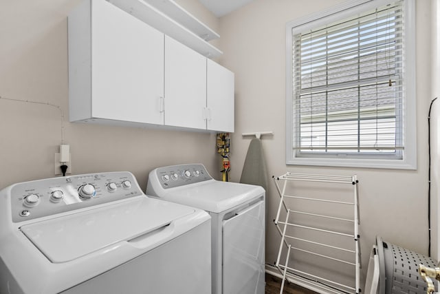 washroom featuring washer and clothes dryer, cabinets, and plenty of natural light