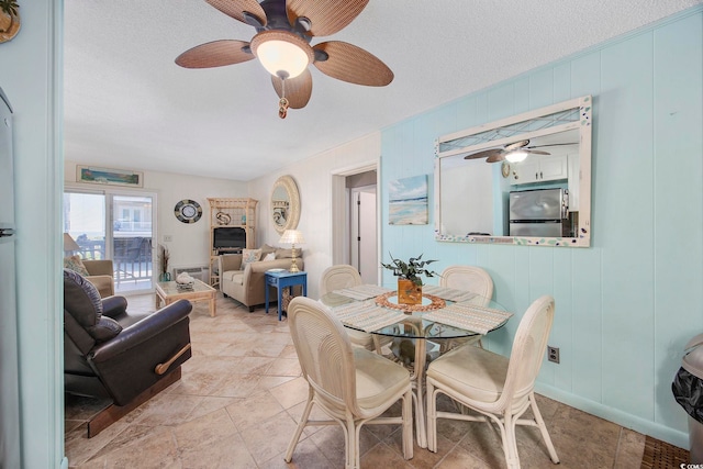 dining area with a textured ceiling and ceiling fan