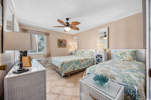 tiled bedroom with a wall mounted air conditioner, a textured ceiling, and ceiling fan